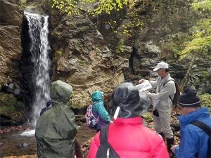 大明神の滝の解説を聞く参加者