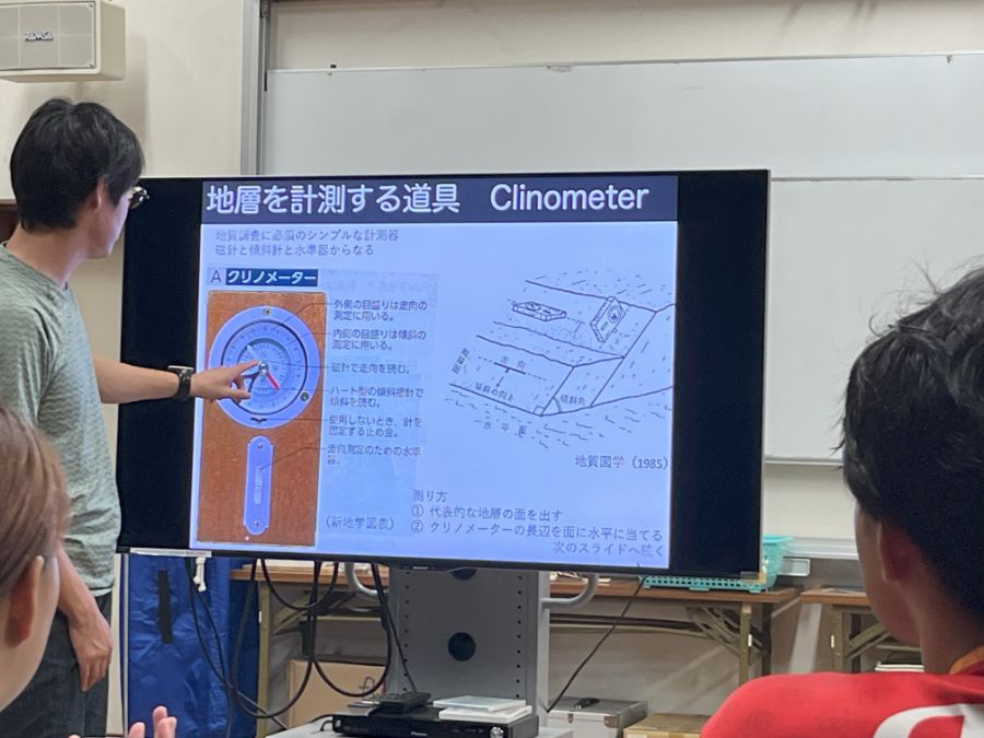 翌日の観測に使うクリノメーター(地層を計測する器具)の説明